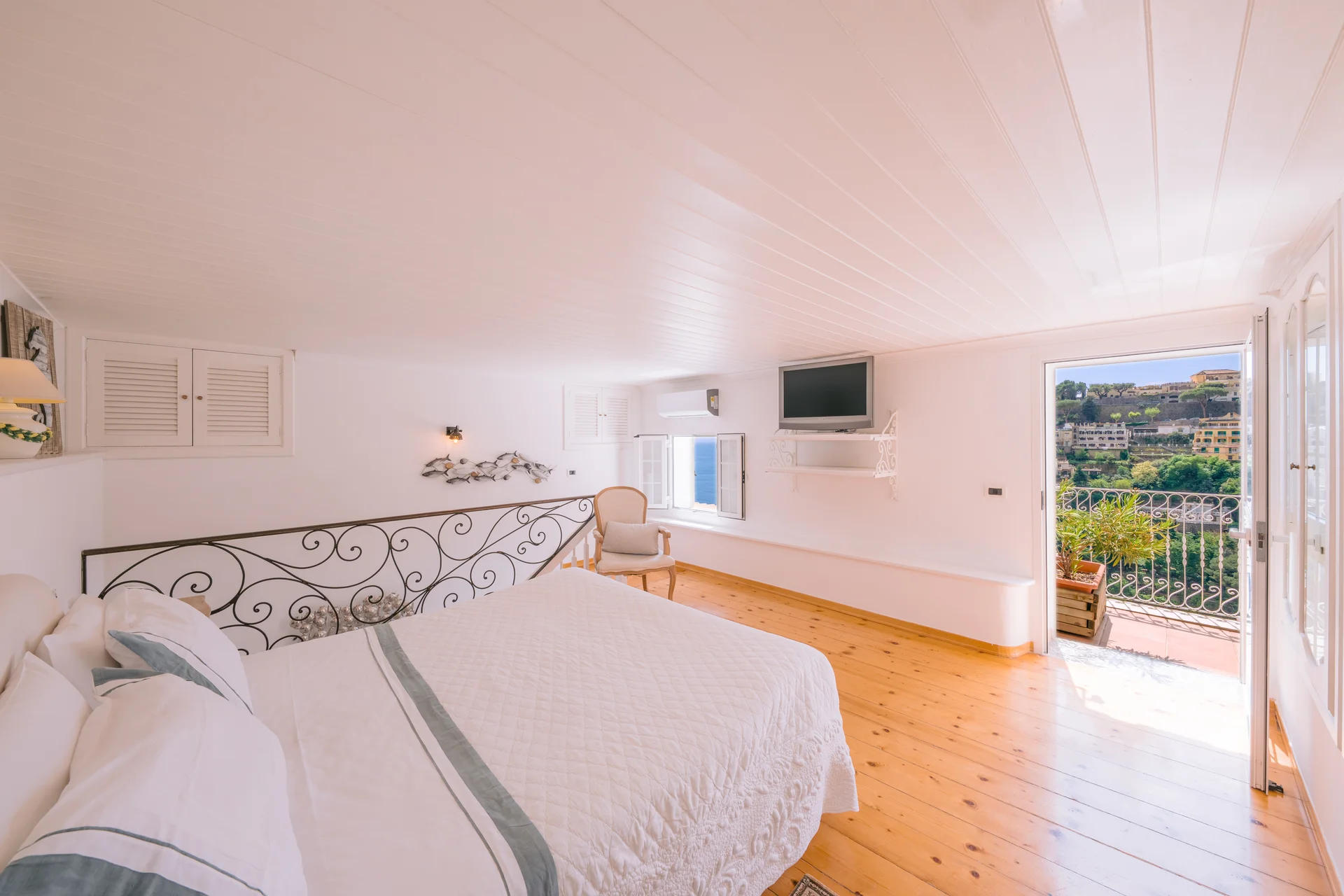 Camera matrimoniale con letto in ferro battuto e vista mare