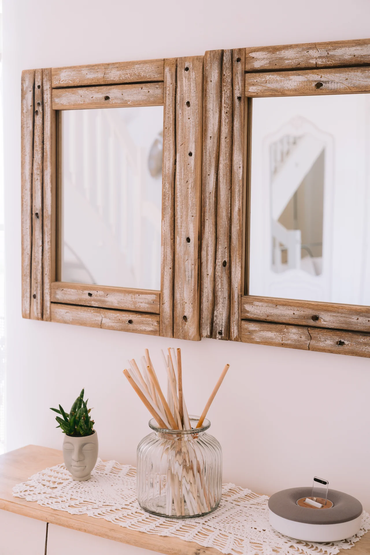 Dettaglio d'arredo con specchio in legno e composizione floreale